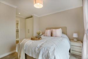 a bedroom with a white bed with a basket on it at 2 Bed in Evesham oc-f33689 in Admington