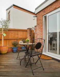 a patio with a table and chairs on a deck at The Annex @ 136 in Gloucestershire