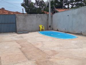 a yellow plastic chair sitting in a backyard swimming pool at Diony in Brotas