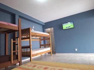a room with two bunk beds and a tv on the wall at Diony in Brotas