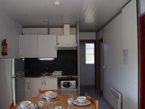 a kitchen with a table and a kitchen with white cabinets at Chalet 35m² avec Terrasse, 2 Chambres - API-1-52-1014 in Boulogne-sur-Gesse