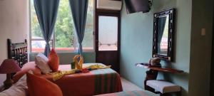 a bedroom with a bed with a mirror and a window at Hotel La Cabaña in Puerto Ángel