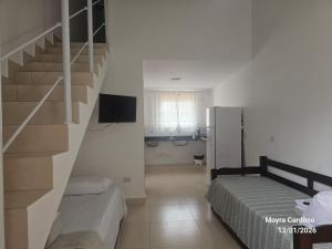 a room with a staircase and a bed and a television at Flor de Jagube Guest House in Ubatuba