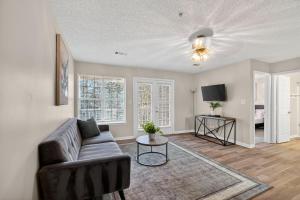 a living room with a couch and a tv at Bright Stockbridge condo with full kitchen in Stockbridge