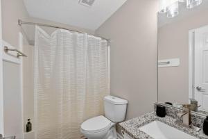 a white bathroom with a toilet and a sink at Bright Stockbridge condo with full kitchen in Stockbridge +13 photos