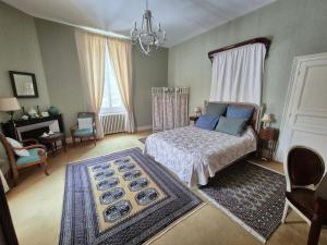 a bedroom with a bed and a chandelier at Le manoir d'Estiveaux in Le Châtelet +29 photos
