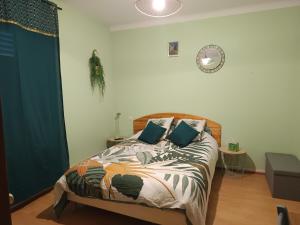 a bedroom with a bed with blue pillows at La clef du ban in Ban-sur-Meurthe-Clefcy +6 photos