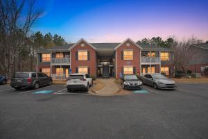 a large house with cars parked in a parking lot at Bright Stockbridge condo with full kitchen in Stockbridge