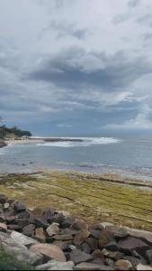 a beach with rocks and the ocean on a cloudy day at Costal View-Ahangama in Ahangama +9 photos