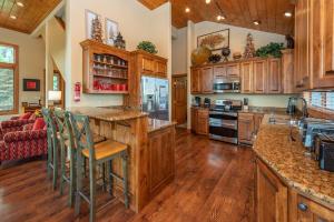 a kitchen with wooden cabinets and a large island with bar stools at Firefly Cove by Railey Vacations in McHenry