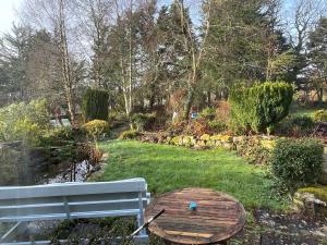 a wooden bench and a table in a garden at Cloonaveel House in Letterbreen