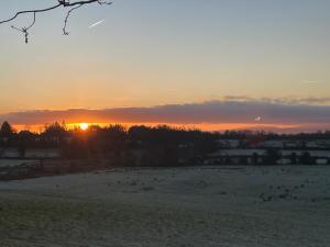 a sunset in a field with the sun setting at Cloonaveel House in Letterbreen +2 photos