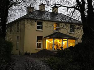 a white house with lights on the front of it at Cloonaveel House in Letterbreen