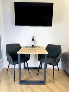 a table with two chairs and a tv on a wall at BEST VIEW Winterberg - Kleines Studio Apartment in Winterberg
