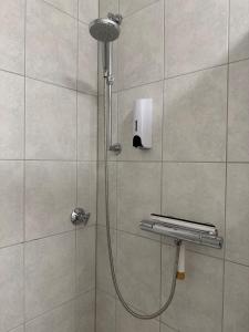 a shower with a shower head in a bathroom at BEST VIEW Winterberg - Kleines Studio Apartment in Winterberg +10 photos