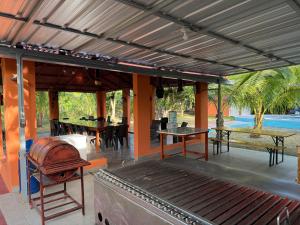an outdoor patio with tables and a grill at Rancho Doña Rita in Higuey