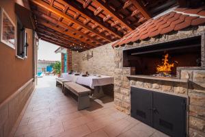 an outdoor patio with a table and a fireplace at Villa Peaceful Valley in Šestanovac