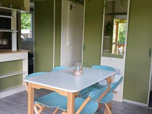 a table and chairs in a kitchen with green walls at Chalet 5 Pers avec Terrasse - API-1-52-1125 in Vendoire