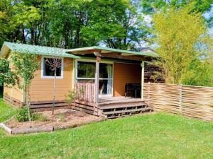 a tiny house with a porch in a yard at Chalet 5 Pers avec Terrasse - API-1-52-1125 in Vendoire