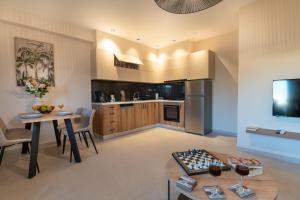 a kitchen with a table and a dining room at Mystrali 1BD Modern Apt with Private Garden in Galatás
