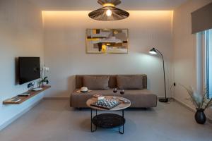 a living room with a couch and a table at Mystrali 1BD Modern Apt with Private Garden in Galatás