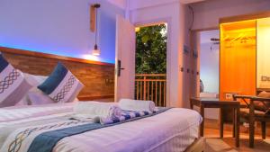 a bedroom with two beds and a balcony at Rivethi Veyli Ukulhas in Ukulhas