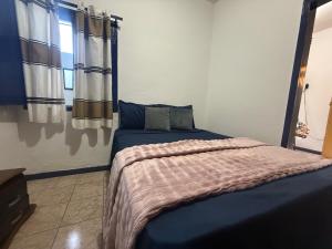 a bedroom with a bed with a blue comforter at Refúgio Colonial 3 - Antonio Dias in Ouro Preto