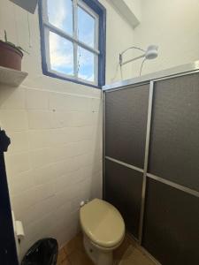 a bathroom with a toilet and a window and a shower at Refúgio Colonial 3 - Antonio Dias in Ouro Preto +8 photos