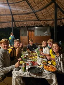 a group of people sitting around a table eating food at Top Manu Avatar Lodge in Pillcopata