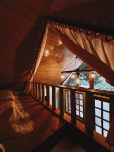 a room with a large window in a cabin at Bangalo Bela Vista in Caparaó Velho