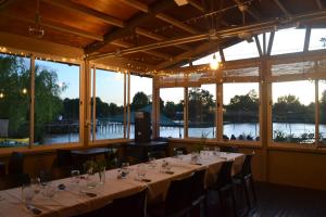 a dining room with tables and chairs and windows at Cabaña DEK in Tigre