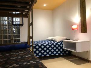 a bedroom with a bed and a dresser with a lamp at Chakraruna Backpackers in Cajamarca