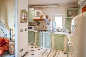 a kitchen with green cabinets and a sink at Romantic Sea View Flat in Genova in Genoa