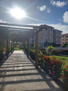 a walkway in a park with flowers and a building at Residencial Clube Recanto dos Coqueiros in Aracaju