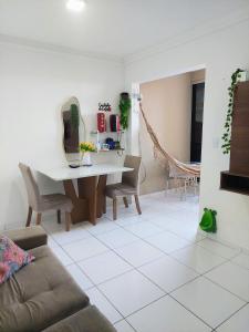 a living room with a table and a couch at Residencial Clube Recanto dos Coqueiros in Aracaju