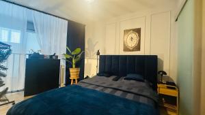 a bedroom with a large bed and a clock on the wall at Apartamenty Zamość Sienkiewicza in Zamość