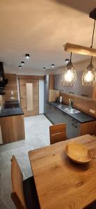 a kitchen with a wooden table and some lights at alter Hannelerhof in Mutters