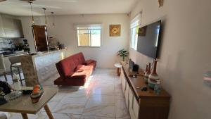 a living room with a red couch and a kitchen at Jacumã Gold in Conde