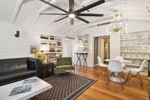 a living room with a ceiling fan and a table and chairs at Speakeasy Hotel in Palm Springs