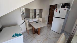 a small kitchen with a table and a refrigerator at Jacumã Gold in Conde +10 photos
