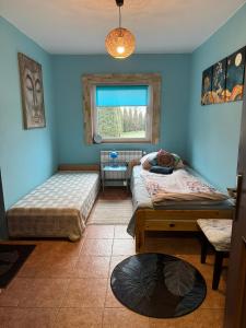 a bedroom with two beds and a window at Zakątek Transformacji in Łużna