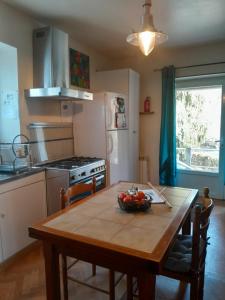 a kitchen with a table with a bowl of fruit on it at Gite "La Méluzine" Avallon, Vézelay, Morvan in Magny +46 photos