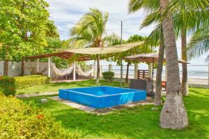 a backyard with a blue pool and palm trees at Casa Libre Guest House in Conchagua