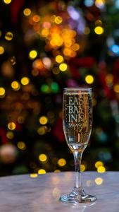 a wine glass sitting on a table with a christmas tree in the background at East Bay Inn, Historic Inns of Savannah Collection in Savannah