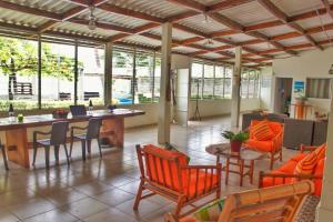 a living room with orange chairs and a table at Casa Libre Guest House in Conchagua