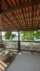 a screened in porch with a view of the ocean at Apartamento Rangel in Cairu