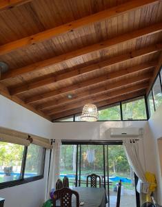 a dining room with a table and some windows at Quinta con pileta in Brandsen
