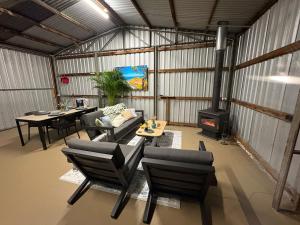 a living room with a couch and chairs and a stove at Ukiyo Nature Retreat in Fingal