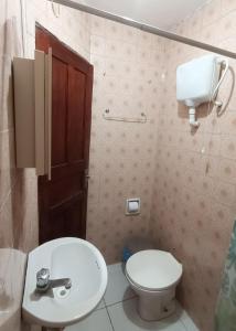 ein Badezimmer mit einem weißen Waschbecken und einer Toilette in der Unterkunft Agro Villa in Areia