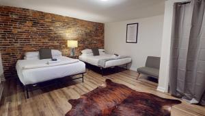 a room with two beds and a brick wall at The Lofts at 107 in Nashville